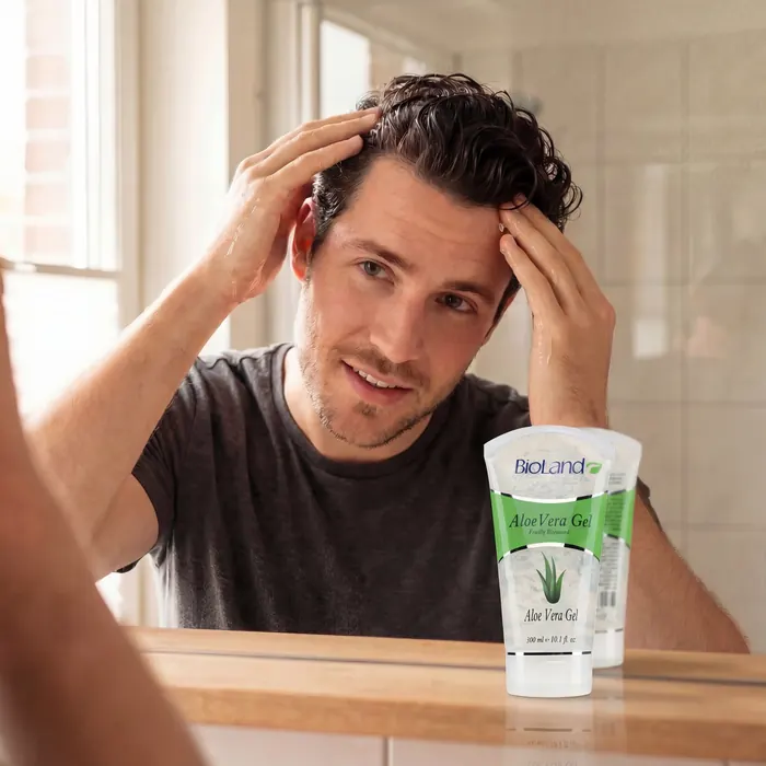 Working aloe gel through hair at the mirror